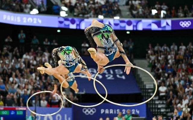 Italy's gymnasts perform with the hoop as they compete in the rhytmic gymnastics' group all-around final during the Paris 2024 Olympic Games at the Porte de la Chapelle Arena in Paris, on August 10, 2024. (Photo by Gabriel BOUYS / AFP)