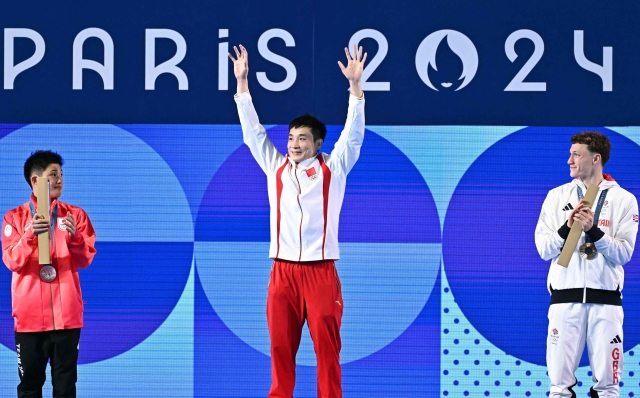 (L-R) Silver medallist Japan's Rikuto Tamai, gold medallist China's Cao Yuan and bronze medallist Britain's Noah Williams stand on the podium after the men's 10m platform diving final during the Paris 2024 Olympic Games at the Aquatics Centre in Saint-Denis, north of Paris, on August 10, 2024. (Photo by Manan VATSYAYANA / AFP)