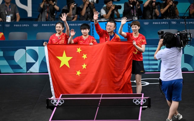 China's team celebrate after China won the women's table tennis team gold medal match between China and Japan at the Paris 2024 Olympic Games at the South Paris Arena in Paris on August 10, 2024. (Photo by WANG Zhao / AFP)