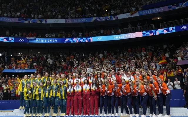 Members of team Spain, center, stand on the podium after winning gold in the women's water polo beside silver medalists Australia, left, and bronze medalists Netherlands at the 2024 Summer Olympics, Saturday, Aug. 10, 2024, in Paris, France. (AP Photo/Luca Bruno)