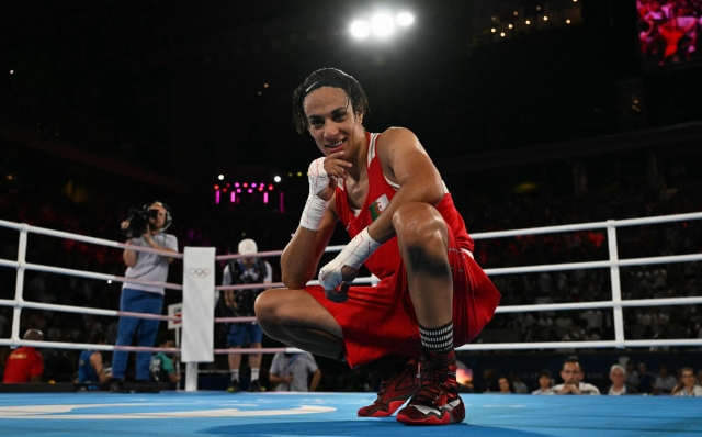 TOPSHOT - Algeria's Imane Khelif reacts after beating China's Yang Liu (Blue) in the women's 66kg final boxing match during the Paris 2024 Olympic Games at the Roland-Garros Stadium, in Paris on August 9, 2024. (Photo by MOHD RASFAN / AFP)