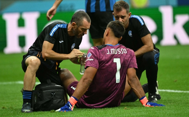 Atalanta's Argentine goalkeeper #01 Juan Musso gets medical treatment on the pitch during the UEFA Super Cup football match between Real Madrid and Atalanta BC in Warsaw, on August 14, 2024. (Photo by Sergei GAPON / AFP)