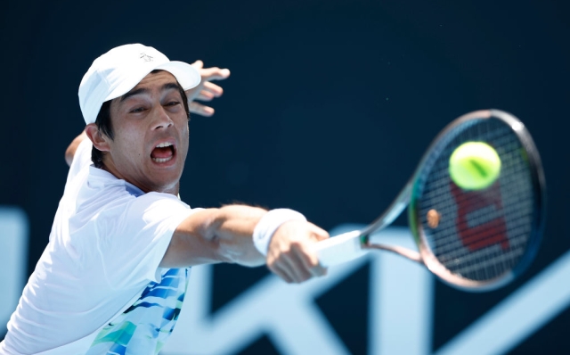 MELBOURNE, AUSTRALIA - JANUARY 16: Mackenzie McDonald of the United States plays a backhand in their round one singles match against Brandon Nakashima of the United States during day one of the 2023 Australian Open at Melbourne Park on January 16, 2023 in Melbourne, Australia. (Photo by Daniel Pockett/Getty Images)