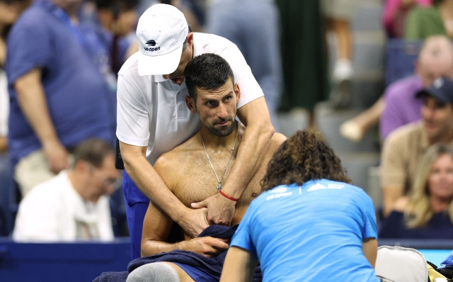 Serbia's Novak Djokovic receives medical attention during his men's singles second round tennis match against Serbia's Laslo Djere on day three of the US Open tennis tournament at the USTA Billie Jean King National Tennis Center in New York City, on August 28, 2024. (Photo by CHARLY TRIBALLEAU / AFP)