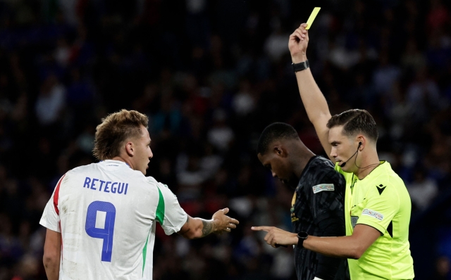 Swiss referee Sandro Scharer gives a yellow card to Italy's forward #09 Mateo Retegui during the UEFA Nations League Group A2 football match between France and Italy at the Parc des Princes in Paris on September 6, 2024. (Photo by STEPHANE DE SAKUTIN / AFP)