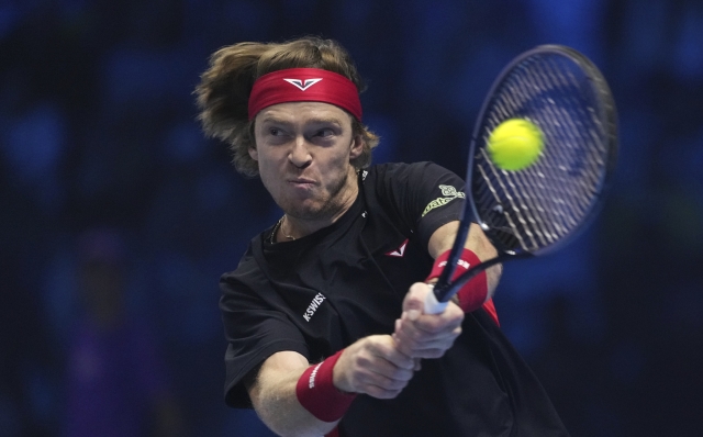 Russia's Andrey Rublev returns the ball to Norway's Casper Ruud during their singles tennis match of the ATP World Tour Finals at the Inalpi Arena, in Turin, Italy, Friday, Nov. 15, 2024. (AP Photo/Antonio Calanni)