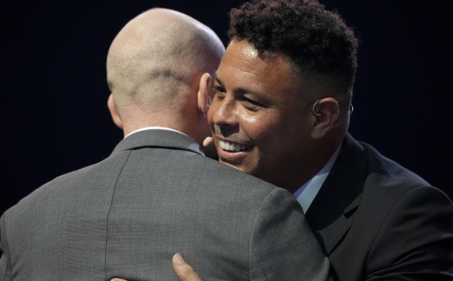 Former professional Brazilian soccer player Ronaldo, right, meets an embrace during the draw for the 2025 FIFA Club World Cup soccer tournament, Thursday, Dec. 5, 2024, in Miami. (AP Photo/Rebecca Blackwell)