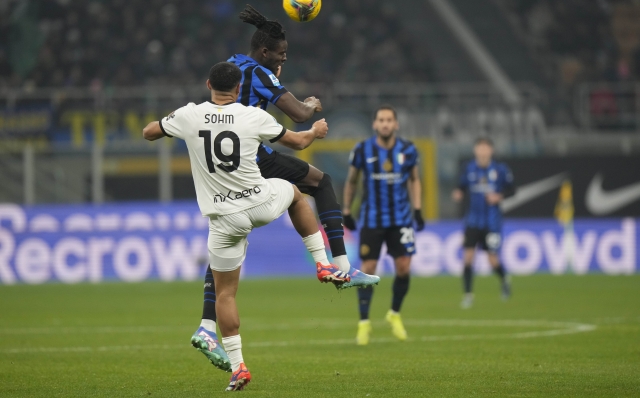 Inter Milan's Yann Aurel Bisseck, right, and Parma's Simon Sohm vie for the ball during a Serie A soccer match between Inter Milan and Parma at the San Siro stadium in Milan, Italy, Friday, Dec.6, 2024. (AP Photo/Luca Bruno)