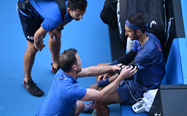 MELBOURNE, AUSTRALIA - JANUARY 18: Lorenzo Musetti of Italy receives medical treatmentin the Men's Singles Third Round match against Ben Shelton of the United States during day seven of the 2025 Australian Open at Melbourne Park on January 18, 2025 in Melbourne, Australia. (Photo by Hannah Peters/Getty Images)