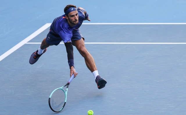 Italy's Lorenzo Musetti hits a return to USA's Ben Shelton during their men's singles match on day seven of the Australian Open tennis tournament in Melbourne on January 18, 2025. (Photo by Adrian DENNIS / AFP) / -- IMAGE RESTRICTED TO EDITORIAL USE - STRICTLY NO COMMERCIAL USE --