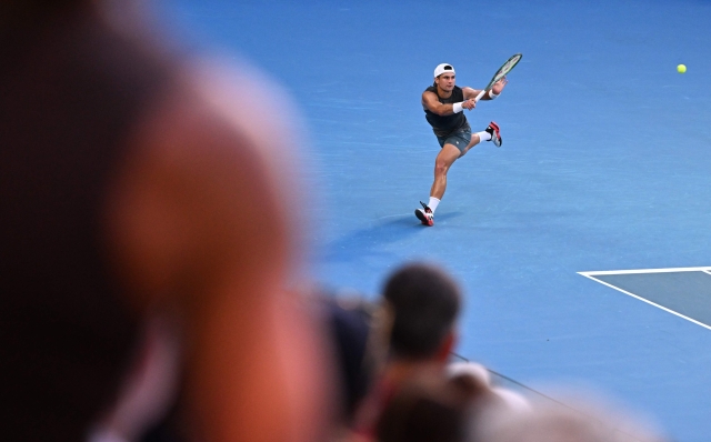 USA?s Marcos Giron hits a return against Italy's Jannik Sinner during their men's singles match on day seven of the Australian Open tennis tournament in Melbourne on January 18, 2025. (Photo by WILLIAM WEST / AFP) / -- IMAGE RESTRICTED TO EDITORIAL USE - STRICTLY NO COMMERCIAL USE --