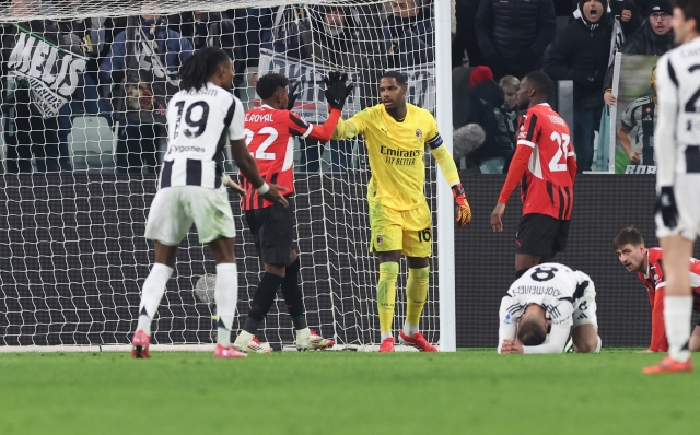 TURIN, ITALY - JANUARY 18:  Mike Maignan of AC Milan reacts with Emerson Royal during the Serie A match between Juventus and AC Milan at  on January 18, 2025 in Turin, Italy. (Photo by Claudio Villa/AC Milan via Getty Images)