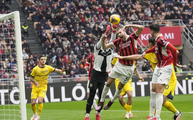 AC Milan's Strahinja Pavlovic is fouled by Parma's goalkeeper Zion Suzuki with during a Serie A soccer match between AC Milan and Parma, at the San Siro stadium in Milan, Italy, Sunday, Jan. 26, 2025. (AP Photo/Luca Bruno)