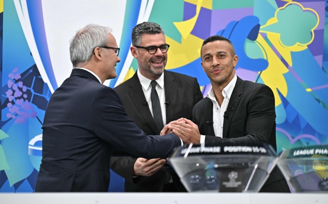 (From L) UEFA Deputy General Secretary Giorgio Marchetti and UEFA Managing Director of Communications Pedro Pinto welcome Former Spanish player Thiago Alcantara on stage during the 2024-2025 UEFA Champions League football tournament knockout play-off draw at the House of European football in Nyon, on January 31, 2025. (Photo by Fabrice COFFRINI / AFP)