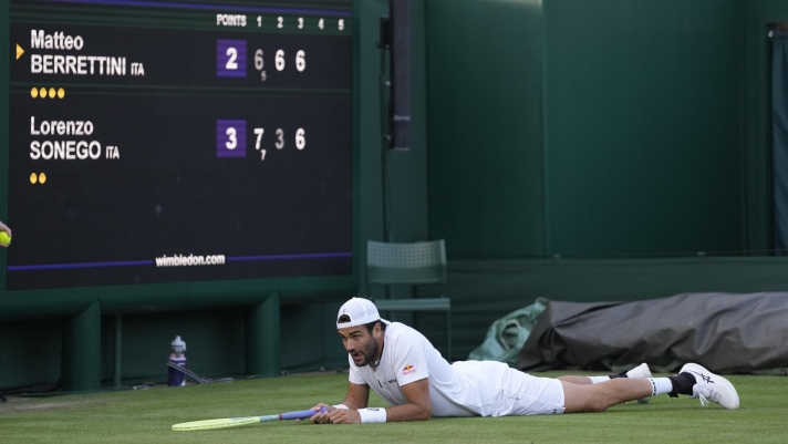 Italy's Matteo Berrettini lays on the court as he plays Italy's Lorenzo Sonego in a first round men's singles match on day three of the Wimbledon tennis championships in London, Wednesday, July 5, 2023. (AP Photo/Kirsty Wigglesworth)