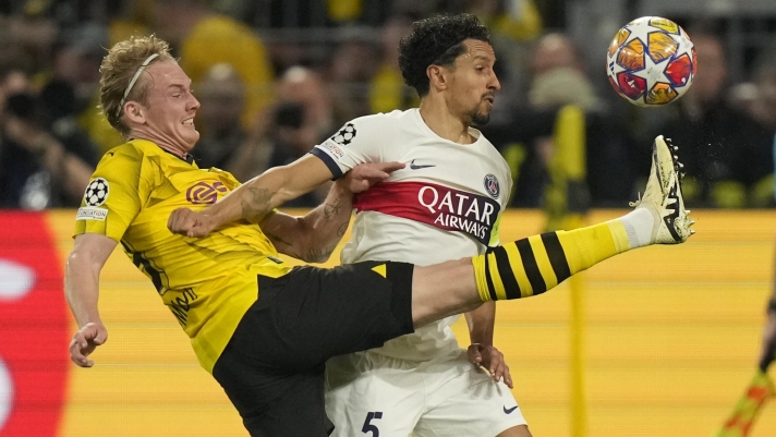PSG's Marquinhos, right, is challenged by Dortmund's Julian Brandt during the Champions League semifinal first leg soccer match between Borussia Dortmund and Paris Saint-Germain at the Signal-Iduna Park stadium in Dortmund, Germany, Wednesday, May 1, 2024. (AP Photo/Matthias Schrader)