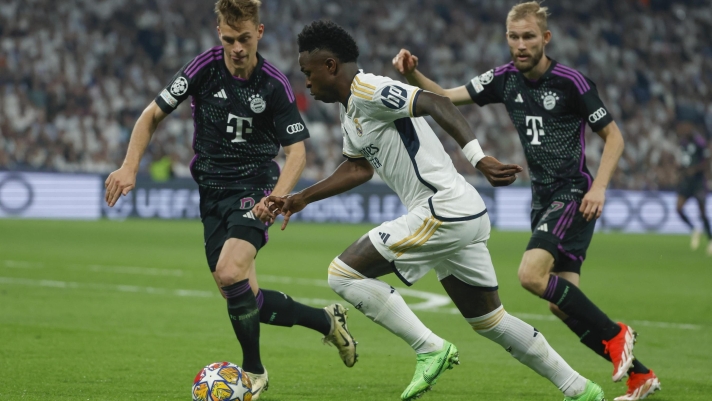 epa11327878 Real Madrid's Vinicius Jr. (C) in action against Bayern Munich's Joshua Kimmich (L) and Konrad Laimer during the UEFA Champions League semifinal second leg soccer match between Real Madrid and Bayern Munich, in Madrid, Spain, 08 May 2024.  EPA/JUANJO MARTIN