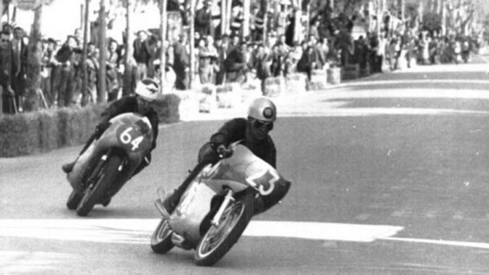 Primo maggio 1962, sulle strade di Cesenatico va in scena la grande sfida tra le moto italiane e giapponesi: Silvio Grassetti con la Benelli cade, danneggia la sua 250 ma si rialza lanciandosi all’inseguimento delle Honda: ed entra nella leggenda...