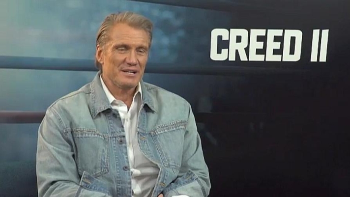 Dolph Lundgren ritorna nei panni di Ivan Drago, il pugile russo che in Rocky IV uccide sul ring Apollo Creed e che affronta Balboa in un match entrato nella storia del cinema. Rivedremo il glaciale Drago in Creed II (nelle sale dal 24 gennaio), nei panni dell'allenatore del figlio Viktor, pronto a combattere contro il figlio di Apollo, Adonis Creed (Michael B. Jordan), allenato da Rocky. Una nuova sfida tra Drago e lo stallone italiano, questa volta a bordo ring. Abbiamo incontrato Dolph Lundgren che ci ha detto la sua su Creed II e sul passato di Drago, che ritorna sullo schermo dopo 33 anni. (Emanuele Bigi)