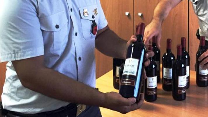 Un sequestro di bottiglie di vino con etichette contraffatte. Ansa