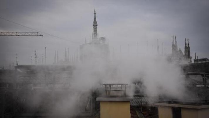 Fumo che esce dai camini a Milano vicino al Duomo. Ansa