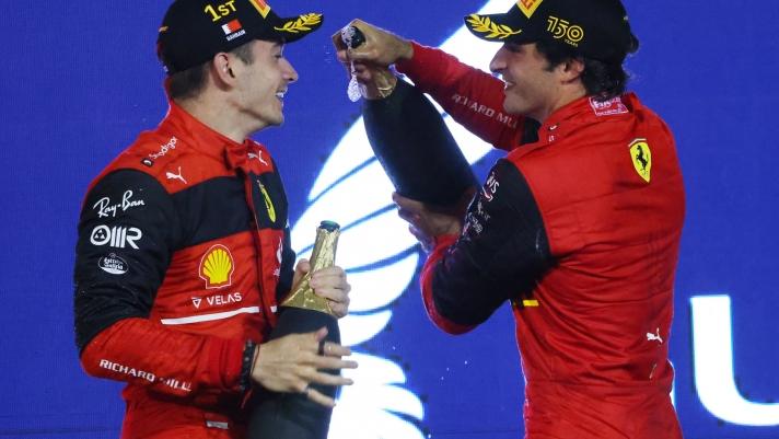Winner Ferrari's Monegasque driver Charles Leclerc (L) and second place Ferrari's Spanish driver Carlos Sainz Jr celebrate on the podium winning the Bahrain Formula One Grand Prix at the Bahrain International Circuit in the city of Sakhir on March 20, 2022. (Photo by Giuseppe CACACE / AFP)