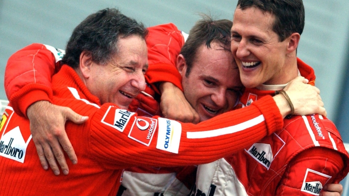 SCHUMACHER CON TODT E BARRICHELLO -German driver Michael Schumacher of Ferrari celebrates with the team's General Director Jean Todt (L) and Brazilian team-mate Rubens Barrichello (C) after clinching the driver's title following the Japanese Formula One Grand Prix in Suzuka, Sunday 12 October 2003. Schumacher placed 8th today, winning a record sixth world championship title. Barrichello won today's race. ANSA /KAY NIETFELD/JI