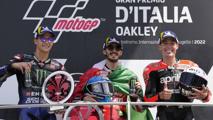 From left, second placed France's Fabio Quartaro, first placed Italy's Francesco Bagnaia and third placed Spain's Aleix Espargaro celebrate on the podium at the end of the Moto2 Grand Prix in Scarperia, Italy, Sunday, May 29, 2022. (AP Photo/Antonio Calanni)