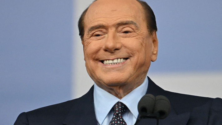 (FILES) In this file photo taken on September 22, 2022 Forza Italia leader Silvio Berlusconi speaks on stage during a joint rally of Italy's right-wing parties Brothers of Italy (Fratelli d'Italia, FdI), the League (Lega) and Forza Italia at Piazza del Popolo in Rome, ahead of the September 25 general election. - An Italian court is set to rule on February 15, 2023 on whether billionaire ex-prime minister Silvio Berlusconi bribed witnesses to lie about his "bunga bunga" parties in an underage prostitution case. (Photo by Alberto PIZZOLI / AFP)