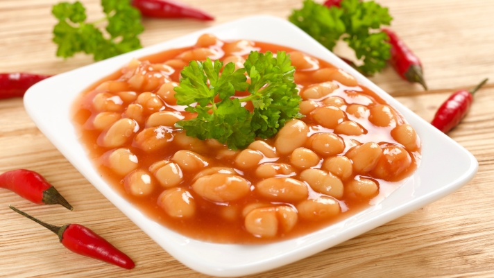 white beans in tomato sauce on wooden background