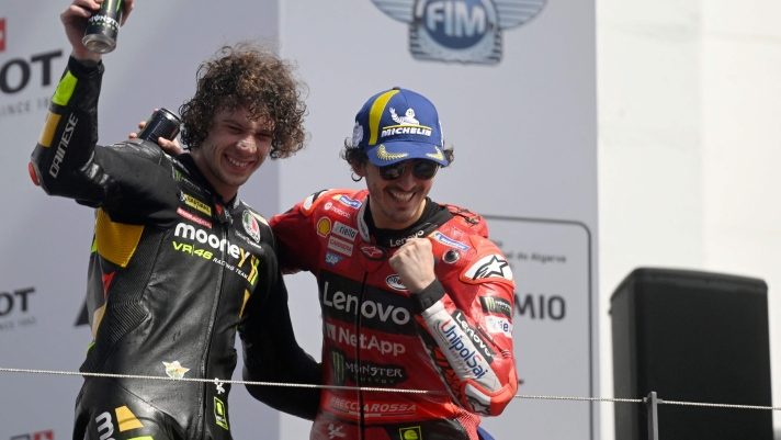 Ducati Italian rider Francesco Bagnaia (R) celebrates his victory with third placed Ducati Italian rider Marco Bezzecchi on the podium of the MotoGP race of the Portuguese Grand Prix at the Algarve International Circuit in Portimao, on March 26, 2023. (Photo by PATRICIA DE MELO MOREIRA / AFP)