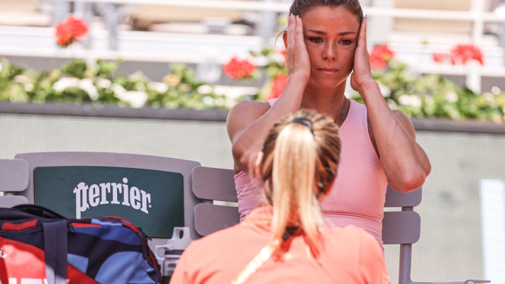 Italy's Camila Giorgi speaks with medical staff member as she plays against US Jessica Pegula during their women's singles match on day four of the Roland-Garros Open tennis tournament at the Court Philippe-Chatrier in Paris on May 31, 2023. (Photo by Thomas SAMSON / AFP)
