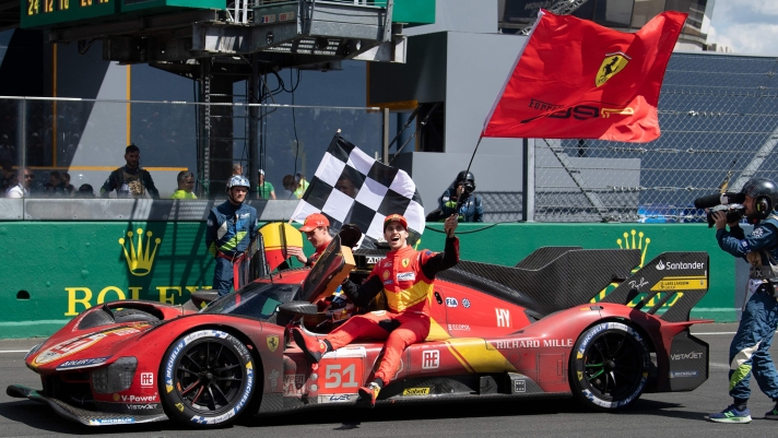 Ferrari N.51 499P Hypercar drivers British James Calado (L) and Italian Antonio Giovinazzi (R) join Italian Alessandro Pier Guidi (car) to celebrate after winning the 24 hours of Le Mans endurance race on June 11, 2023. This year marks the 100th anniversary of the race. (Photo by Fred TANNEAU / AFP)