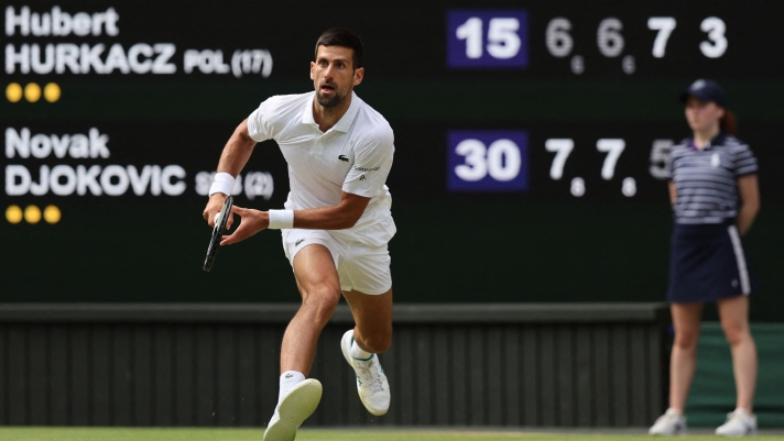 Serbia's Novak Djokovic runs to play a return against Poland's Hubert Hurkacz during their men's singles tennis match on the eighth day of the 2023 Wimbledon Championships at The All England Tennis Club in Wimbledon, southwest London, on July 10, 2023. (Photo by Adrian DENNIS / AFP) / RESTRICTED TO EDITORIAL USE