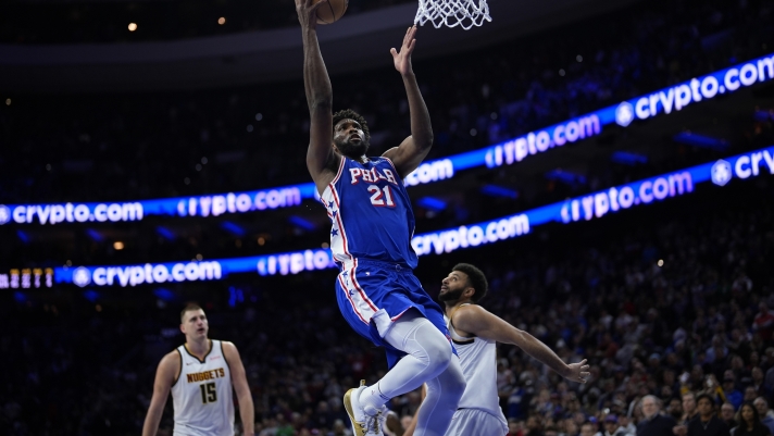 Philadelphia 76ers' Joel Embiid, left, goes up for a shot past Denver Nuggets' Jamal Murray during the second half of an NBA basketball game, Tuesday, Jan. 16, 2024, in Philadelphia. (AP Photo/Matt Slocum)