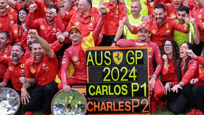 TOPSHOT - Winner Ferrari's Spanish driver Carlos Sainz Jr (front centre L) and second-placed Ferrari's Monegasque driver Charles Leclerc (front centre R) celebrate with their team after the Australian Formula One Grand Prix at Albert Park Circuit in Melbourne on March 24, 2024. (Photo by WILLIAM WEST / AFP) / -- IMAGE RESTRICTED TO EDITORIAL USE - STRICTLY NO COMMERCIAL USE --