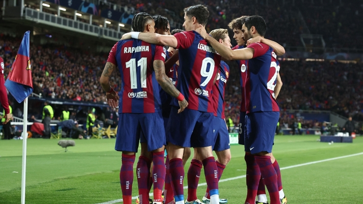Barcelona's Brazilian forward #11 Raphinha celebrates with teammates after scoring his team's first goal during the UEFA Champions League quarter-final second leg football match between FC Barcelona and Paris SG at the Estadi Olimpic Lluis Companys in Barcelona on April 16, 2024. (Photo by FRANCK FIFE / AFP)