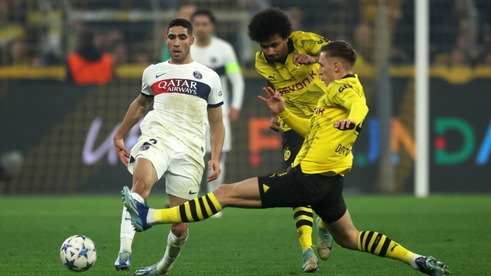 DORTMUND, GERMANY - DECEMBER 13: Achraf Hakimi of Paris Saint-Germain is challenged by Karim Adeyemi and Nico Schlotterbeck of Borussia Dortmund during the UEFA Champions League match between Borussia Dortmund and Paris Saint-Germain at Signal Iduna Park on December 13, 2023 in Dortmund, Germany. (Photo by Alex Grimm/Getty Images)