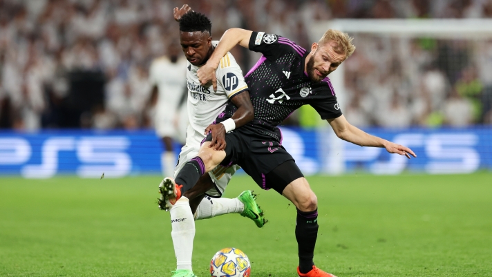 MADRID, SPAIN - MAY 08: Vinicius Junior of Real Madrid is challenged by Konrad Laimer of Bayern Munich during the UEFA Champions League semi-final second leg match between Real Madrid and FC Bayern München at Estadio Santiago Bernabeu on May 08, 2024 in Madrid, Spain. (Photo by Alexander Hassenstein/Getty Images)