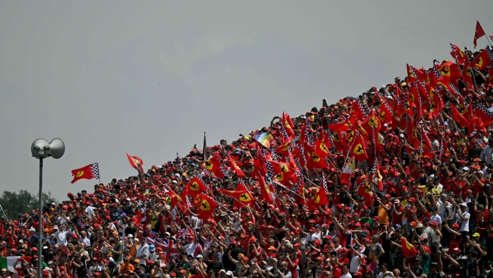 Spectators wave Ferrari flags prior to the Emilia Romagna Formula One Grand Prix at the Autodromo Enzo e Dino Ferrari race track in Imola on May 19, 2024. (Photo by ANDREJ ISAKOVIC / AFP)