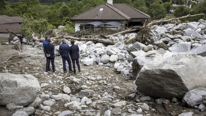 From left, Swiss Federal Councillor Ignazio Cassis, William Kloter, commander of the Cantonal Police of Graubuenden, Jon Domenic Parolini, President of the Government of canton Graubuenden and Christian Vitta, President of the Government of canton Ticino, inspect the site of a landslide, caused by severe weather and heavy rain in the Misox valley, in Sorte village, Lostallo, southern Switzerland on Sunday June 23, 2024. Authorities in Switzerland say rescuers have found the body of one of three people who had gone missing on Saturday after massive thunderstorms and rainfall in the southeast of the county caused a rockslide. (Michael Buholzer/Keystone via AP)