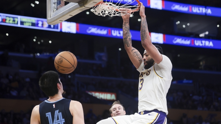 Los Angeles Lakers forward Anthony Davis (3) dunks as Memphis Grizzlies center Zach Edey (14) watches during the second half of an NBA basketball game, Sunday, Dec. 15, 2024, in Los Angeles. (AP Photo/Jessie Alcheh)