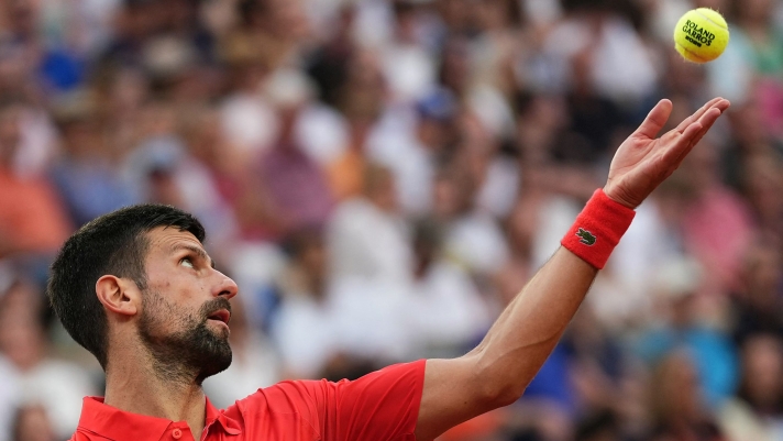 TOPSHOT - Serbia's Novak Djokovic serves to France's Corentin Moutet during their men's singles match on day 5 of the French Open tennis tournament on Court Suzanne-Lenglen at the Roland-Garros Complex in Paris on May 29, 2025. (Photo by Dimitar DILKOFF / AFP)