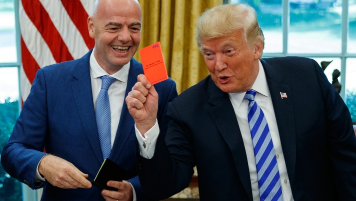 FILE - President Donald Trump holds up a red card during a meeting with FIFA president Gianni Infantino in the Oval Office of the White House, Tuesday, Aug. 28, 2018, in Washington. (AP Photo/Evan Vucci, File)
