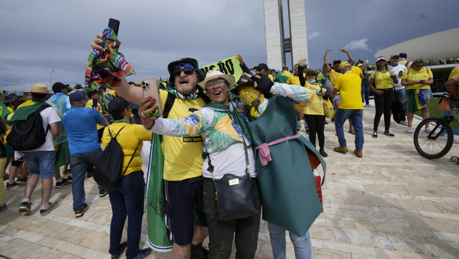Protesters, supporters of Brazil's former President Jair Bolsonaro, take selfies as they storm the the National Congress building in Brasilia, Brazil, Sunday, Jan. 8, 2023. (AP Photo/Eraldo Peres)