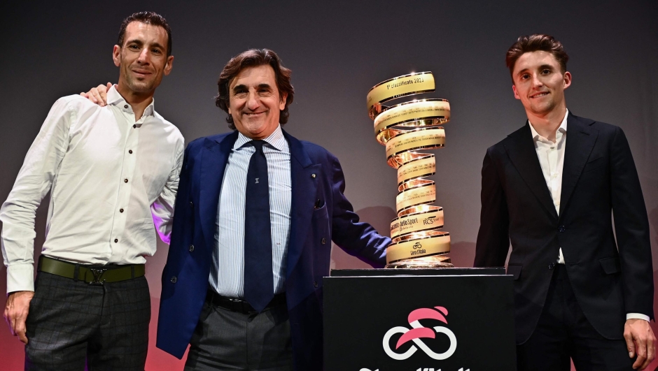 (From L) Italian rider Vincenzo Nibali, founder of Italian media and publishing company Cairo Communication, and President of RCS Media Group, Urbano Cairo and Australian rider Jai Hindley pose with the "Trofeo Senza Fine" (Endless Trophy) race winner's trophy during the presentation of the 2023 Giro d'Italia cycling race on October 17, 2022 in Milan. (Photo by Marco BERTORELLO / AFP)