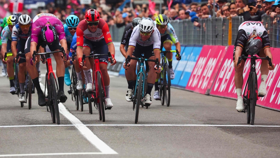 UAE Team Emirates's German rider Pascal Ackermann (R) crosses the finish line to win, ahead of Bahrain - Victorious's Italian rider Jonathan Milan (L) and Astana Qazaqstan Team's British rider Mark Cavendish (C) the eleventh stage of the Giro d'Italia 2023 cycling race, 219 km between Camaiore and Tortona, on May 17, 2023. (Photo by Luca Bettini / AFP)