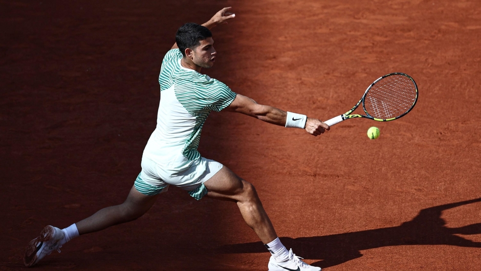 Spain's Carlos Alcaraz Garfia plays a backhand return to Italy's Flavio Cobolli during their men's singles match on day two of the Roland-Garros Open tennis tournament at the Court Suzanne-Lenglen in Paris on May 29, 2023. (Photo by Anne-Christine POUJOULAT / AFP)