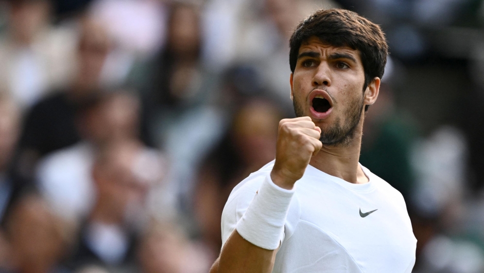 Spain's Carlos Alcaraz reacts as he plays against Denmark's Holger Rune during their men's singles quarter-finals tennis match on the tenth day of the 2023 Wimbledon Championships at The All England Lawn Tennis Club in Wimbledon, southwest London, on July 12, 2023. (Photo by SEBASTIEN BOZON / AFP) / RESTRICTED TO EDITORIAL USE