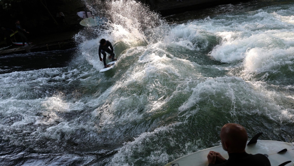 epaselect epa10690984 A surfer rides a wave of the Eisbach creek in the English Garden park in Munich, Germany, 14 June 2023.  EPA/ANNA SZILAGYI